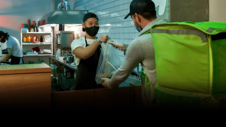 Delivery man getting food at the restaurant.